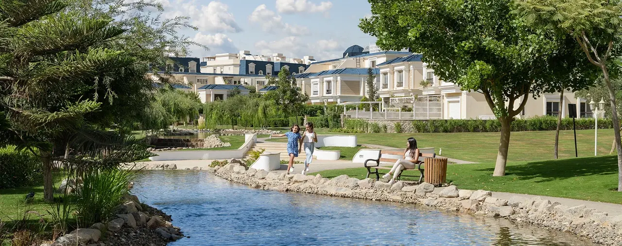 Rendering of a landscaped creek with gardens and residential buildings in the background at CreekView, New Cairo